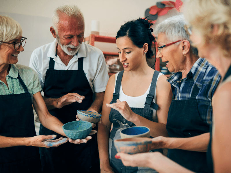 A group of people looking at clay bowls they have painted.